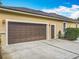 Attached two-car garage with brown doors, tan siding, and ample driveway parking at 19123 Sheldon St, Orlando, FL 32833