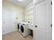 Functional laundry room with appliances, storage shelves, tile floors and lighting at 19123 Sheldon St, Orlando, FL 32833