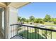 View from the balcony of a condo overlooking the parking area, green spaces, and blue sky at 1932 Lake Atriums Cir # 69, Orlando, FL 32839