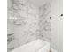 Bright bathroom features a tub with white marble surround and chrome plumbing at 1932 Lake Atriums Cir # 69, Orlando, FL 32839