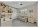 Carpeted bedroom features a sofa, shelving unit and a bright window with curtain at 2040 Mohawk Trl, Maitland, FL 32751