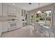 Bright eat-in kitchen with white appliances and cabinets, tile flooring and an adjacent built in desk at 2040 Mohawk Trl, Maitland, FL 32751