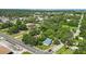 Aerial view of a home with a blue roof surrounded by lush green trees and a cityscape in the distance at 205 S Highland Ave, Apopka, FL 32703