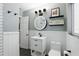 A modern bathroom features a round mirror, wainscotting and black fixtures at 2109 Montana St, Orlando, FL 32803