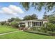 Landscaped front yard with lush green grass, mature trees, and colorful flowerbeds at 2109 Montana St, Orlando, FL 32803