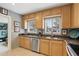 Kitchen with stainless steel appliances and wood cabinets under two sunlit windows at 2109 Montana St, Orlando, FL 32803