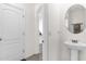 Stylish powder room features a pedestal sink and round mirror in a modern design at 2224 Tay Wes Dr, St Cloud, FL 34771