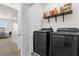 Laundry room with a black washer and dryer and a shelf with cleaning products at 2224 Tay Wes Dr, St Cloud, FL 34771
