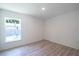 Bright bedroom featuring wood-look flooring, neutral walls, and a window for natural light at 2260 Suanne Ave, Eustis, FL 32726