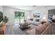 Bright living room boasts sliding glass doors to the yard and is furnished with contemporary neutral furniture at 2260 Suanne Ave, Eustis, FL 32726