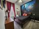 Themed bedroom with a full-sized bed, dark wood accents, and a large decorative mural at 236 Boxwood Dr, Davenport, FL 33837