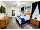 Well-lit main bedroom with ensuite bathroom featuring a decorative headboard, wood-look flooring, and a ceiling fan at 236 Boxwood Dr, Davenport, FL 33837