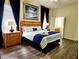 Comfortable main bedroom featuring a decorative headboard, ensuite bathroom, and bright, natural light at 236 Boxwood Dr, Davenport, FL 33837