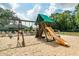 Community playground area with swings, slide, and playhouse set on a sandy base at 236 Boxwood Dr, Davenport, FL 33837