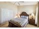 Bedroom features a decorative wood bed frame, side tables, and a closet for storage and convenience at 2481 Deer Creek Blvd, St Cloud, FL 34772