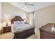 Relaxing bedroom features a decorative wood bed frame, ceiling fan, and natural light from a window at 2481 Deer Creek Blvd, St Cloud, FL 34772