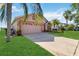 Charming single-Gathering home featuring a two-car garage, palm trees, and driveway at 2481 Deer Creek Blvd, St Cloud, FL 34772