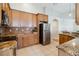 Bright kitchen features wooden cabinetry, granite countertops, stainless steel appliances, and a tiled backsplash at 2481 Deer Creek Blvd, St Cloud, FL 34772