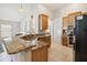 Open-concept kitchen with granite countertops, stainless steel appliances and a breakfast bar overlooking the living area at 2481 Deer Creek Blvd, St Cloud, FL 34772