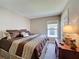 Inviting bedroom with plush bedding, side table with lamp, and a view of the outside at 2641 Hemingway Ave, Haines City, FL 33844