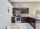 Well-equipped kitchen features dark wood cabinets, stainless steel appliances, and tile backsplash at 2641 Hemingway Ave, Haines City, FL 33844