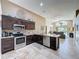 Open kitchen with dark wood cabinets, stainless steel appliances, and view to the living room at 2641 Hemingway Ave, Haines City, FL 33844