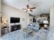Comfortable living room featuring a ceiling fan, mounted TV and views of the eat-in kitchen at 2641 Hemingway Ave, Haines City, FL 33844