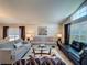 Cozy living room featuring comfortable sofas, a glass coffee table, and large windows with blinds at 2641 Hemingway Ave, Haines City, FL 33844