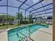 A sunny, screened-in in-ground pool and patio area with lounge chairs at 2641 Hemingway Ave, Haines City, FL 33844