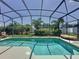 Screened-in pool with crystal clear water, surrounded by lush landscaping in a private backyard setting at 2641 Hemingway Ave, Haines City, FL 33844