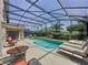 Screened-in in-ground pool and patio with lounge chairs at 2641 Hemingway Ave, Haines City, FL 33844