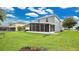 A well-maintained backyard shows a house with a screened lanai and plenty of green grass at 2658 Adele Pl, Lake Mary, FL 32746