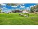 A home with a covered porch and a screened in lanai shows a grassy backyard leading to a lake at 2658 Adele Pl, Lake Mary, FL 32746