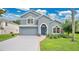 Charming two-story home with a well-manicured lawn, beautiful landscaping, and a blue front door at 2658 Adele Pl, Lake Mary, FL 32746