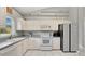 Bright kitchen with white appliances, white cabinetry, tile floors, and updated fixtures at 2658 Adele Pl, Lake Mary, FL 32746