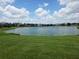 Expansive backyard view overlooking a serene lake surrounded by lush green lawns and community homes at 2710 Gorst Rd, Winter Garden, FL 34787