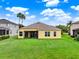 Expansive backyard featuring lush green grass, mature landscaping, and a screened-in lanai at 2710 Gorst Rd, Winter Garden, FL 34787