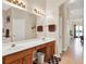 Bathroom with dual sinks, vanity lighting, decorative accents, and an entrance to the main bedroom at 2710 Gorst Rd, Winter Garden, FL 34787