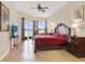 Bright main bedroom featuring tile flooring, a ceiling fan, and a balcony overlooking the water at 2710 Gorst Rd, Winter Garden, FL 34787
