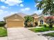 Well-maintained home with lush landscaping, an attached garage, and a manicured front lawn at 2710 Gorst Rd, Winter Garden, FL 34787