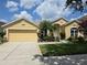 Charming home featuring a lush green lawn, colorful landscaping, and a bright yellow exterior at 2710 Gorst Rd, Winter Garden, FL 34787