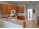 Well-lit kitchen featuring wood cabinets, a breakfast bar, and modern appliances at 2710 Gorst Rd, Winter Garden, FL 34787