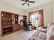 Home office with custom built-in bookshelves, a ceiling fan, and a comfortable sofa at 2710 Gorst Rd, Winter Garden, FL 34787