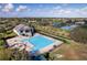 Aerial view of a community pool and clubhouse surrounded by lush landscaping in a beautiful community at 2710 Gorst Rd, Winter Garden, FL 34787