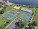 Aerial view of the community's well-maintained tennis and basketball courts near a lake at 2710 Gorst Rd, Winter Garden, FL 34787