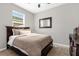Cozy bedroom features a dark wood bed frame and dresser, with natural light from the window at 284 White Heron Way, St Cloud, FL 34772