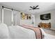 Bright bedroom features mounted TV, modern dresser, and access to adjacent spaces for a seamless living experience at 284 White Heron Way, St Cloud, FL 34772