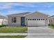 Charming single-story home with a two car garage, manicured lawn and a lovely blue front door at 284 White Heron Way, St Cloud, FL 34772