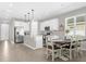Bright kitchen with white cabinetry, stainless steel appliances and a dining table at 284 White Heron Way, St Cloud, FL 34772