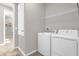 Laundry room with side-by-side washer and dryer, shelving, and neutral paint at 284 White Heron Way, St Cloud, FL 34772